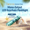 i3E EOS Summer Palm mono-output LED keychain flashlight on beach sand next to seashell