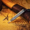 Multitool screwdriver with hex bits on an antique map, wooden handle in background.