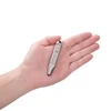 Hand holding a small, sleek titanium pry bar on a white background.