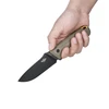 Hand holding a black blade fixed knife with a tan textured handle, isolated on white