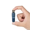 Hand holding tiny blue Olight flashlight, small portable light for keys or everyday carry