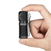 Hand holding a compact black Olight EDC pocket flashlight with clip isolated on white background