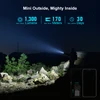 Olight Baton 4 Premium compact flashlight illuminating a dark outdoor rocky landscape, showcasing 1300 lumens and 170m throw.