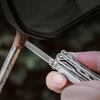 Using Nextool multitool metal file to scrape rust off a motorcycle side mirror stem