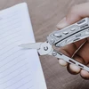 NexTool multi-tool scissors cutting notebook paper page close up
