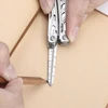 Using a NexTool multi-tool ruler to draw a straight line with a wooden pencil on paper