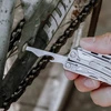 Using a NexTool multi-tool flathead screwdriver to repair a bicycle chain and frame screw.