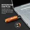 Orange imini 2 flashlight with integrated USB plug charging directly from a laptop for portable power.