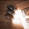 Three PL-3 Valkyrie tactical weapon lights shining bright beams on an FBI file folder on a wooden desk.