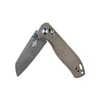 Gray folding knife with textured olive drab handle, blue accents, partially opened, isolated white background.