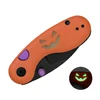 Orange pocket knife with a glow in the dark jack o lantern face purple buttons and black blade for Halloween EDC scaled gear