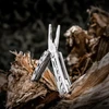 NexTool multi-tool pliers resting on a weathered piece of wood outdoor