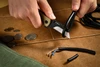 Person cutting a black thick wire with a U1 Ultra utility knife on canvas background