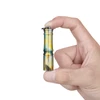 Hand holding a compact Olight i3E EOS keychain flashlight with a tropical palm leaf design isolated on white background