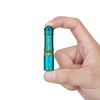 Olight i3E EOS teal and gold pocket-sized keychain flashlight held between two fingers showing its compact size