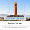 Orange rechargeable flashlight, 3500mAh battery, 6+ days runtime, on rocks by lake, mountains, blue sky