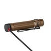 Brown Olight Warrior Mini 3 tactical flashlight charging with a magnetic cable attached to its tailcap.
