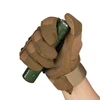 Hand in tactical glove holding green Olight Arkfeld flashlight