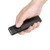 Hand holding Olight Arkfeld Pro flat EDC flashlight with thumb on selector switch isolated on white background