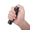 Olight Black Warrior Mini 2 flashlight held in hand, showing the side switch and textured grip for everyday carry.