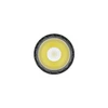 Bright LED flashlight head, top-down view. Yellow-white light, dark textured bezel.