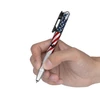 Hand holding a tactical pen with American flag design and glass breaker tip