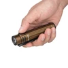 Brown Olight LED flashlight held in hand, showing textured grip and clip.