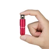 Red Olight mini flashlight held in hand, showing magnetic charging connector.