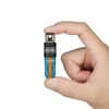Hand holding a small blue and orange flashlight with a checkered pattern and silver top on a white background.