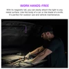 Man using a magnetic hands-free work light attached to a car hood for engine maintenance at night.
