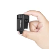 Hand holding compact black Olight Baldr S flashlight, small weapon light, white background