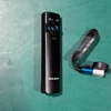 Black Olight Arkfeld flashlight and magnetic charging cable on green surface