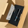 Olight Black Warrior Mini 2 Flashlight in open brown box with blue accents and user manual.