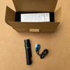 Olight Warrior Mini 2 flashlight with magnetic charger and box, ready for tactical or everyday carry.
