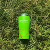 Olight green insulated stainless steel travel tumbler on green grass