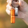 Olight Orange I1R 2 Pro EOS Keychain Flashlight held by hand for everyday carry and illumination.