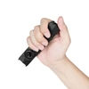 Hand holding a compact black EDC flashlight with flat design and rotary switch against white background