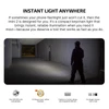 Man shines imini 2 keychain flashlight in a dark hallway, demonstrating bright, reliable illumination.