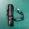 Olight Black Odin Mini tactical flashlight with magnetic charging cable for weapon-mounted illumination