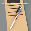 American flag pen with a tactical light and glass breaker, 6.10 inches long, resting on a notepad.