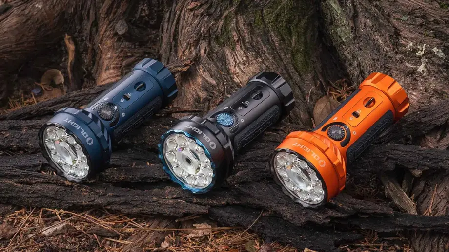 Olight multi-LED flashlights in blue, black, orange on dark tree roots.