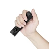 Hand holding compact black EDC pocket flashlight against white background