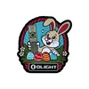 Olight Easter bunny patch holding flashlight, surrounded by colorful eggs and flowers.