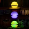 Olight Sphere C Smart RGB light in yellow, purple, and green, illuminating a Halloween party setting.