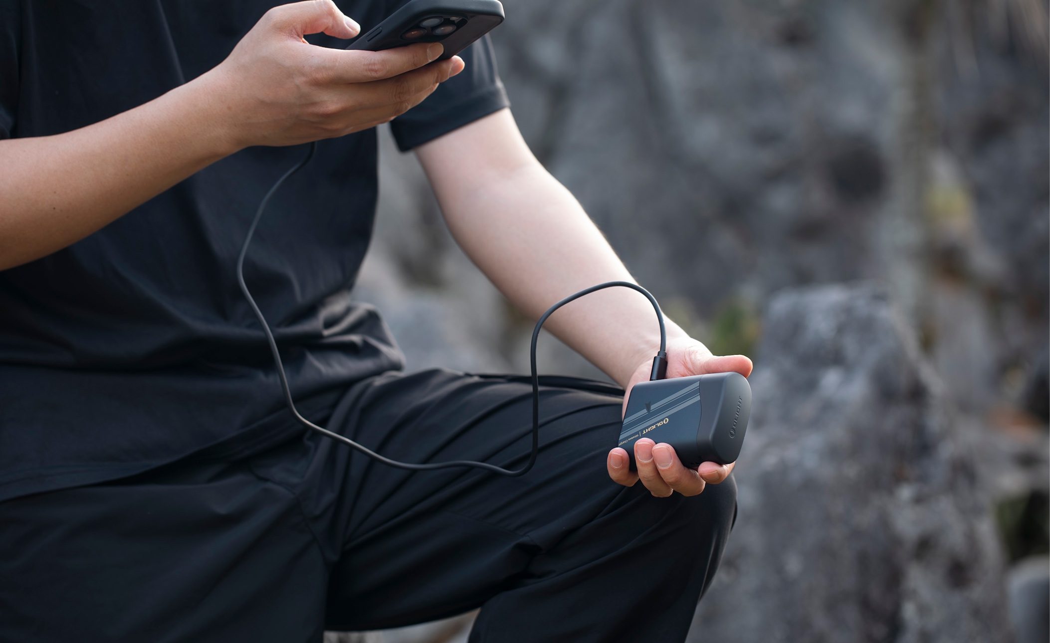 An outdoor scene with a person holding a phone and Olight charging device, captioned 'He's always got the right tool.'